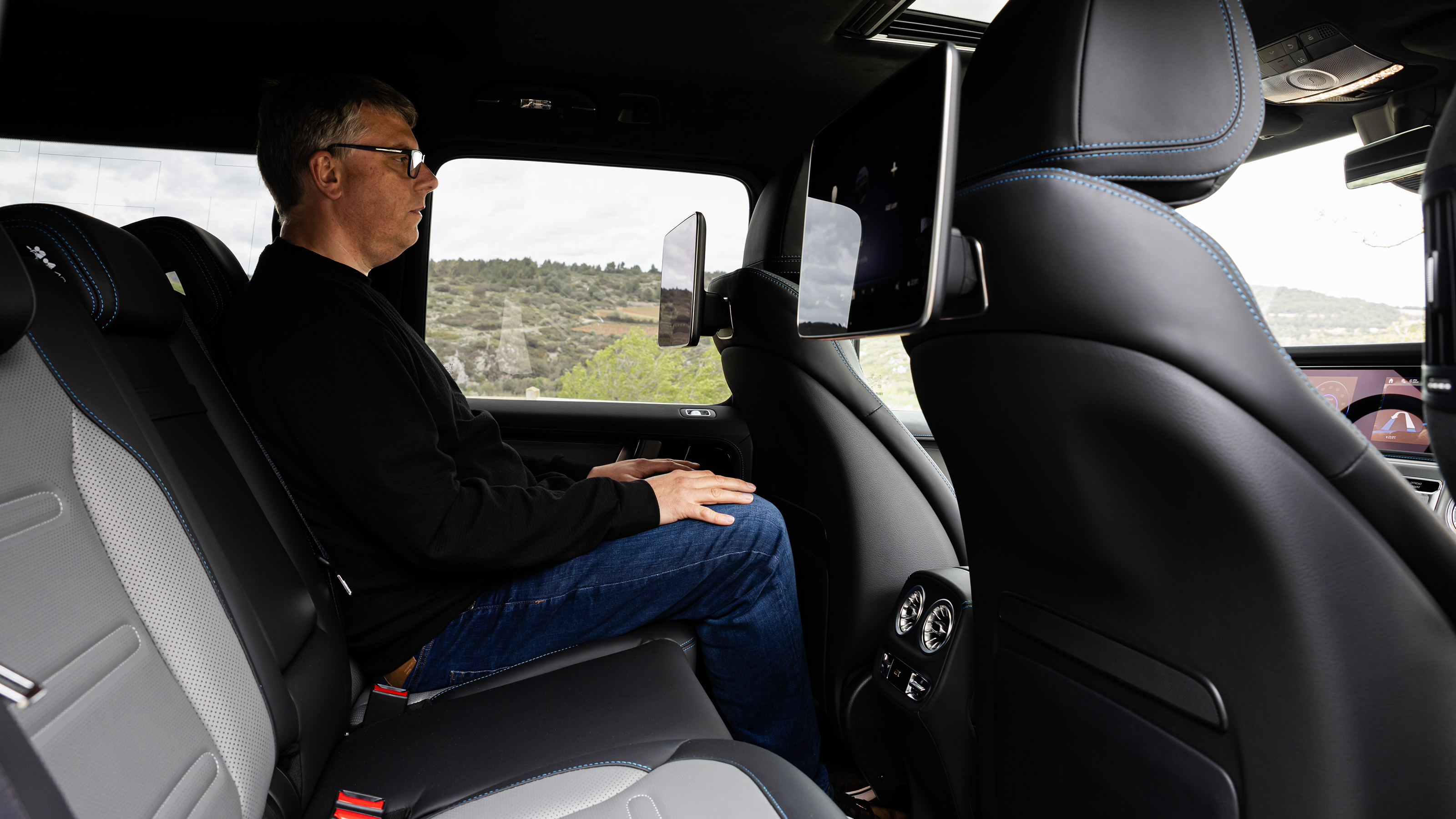 Paul Barker sitting in the Mercedes G 580's back seat