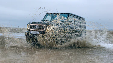 Mercedes G 580 driving through muddy water