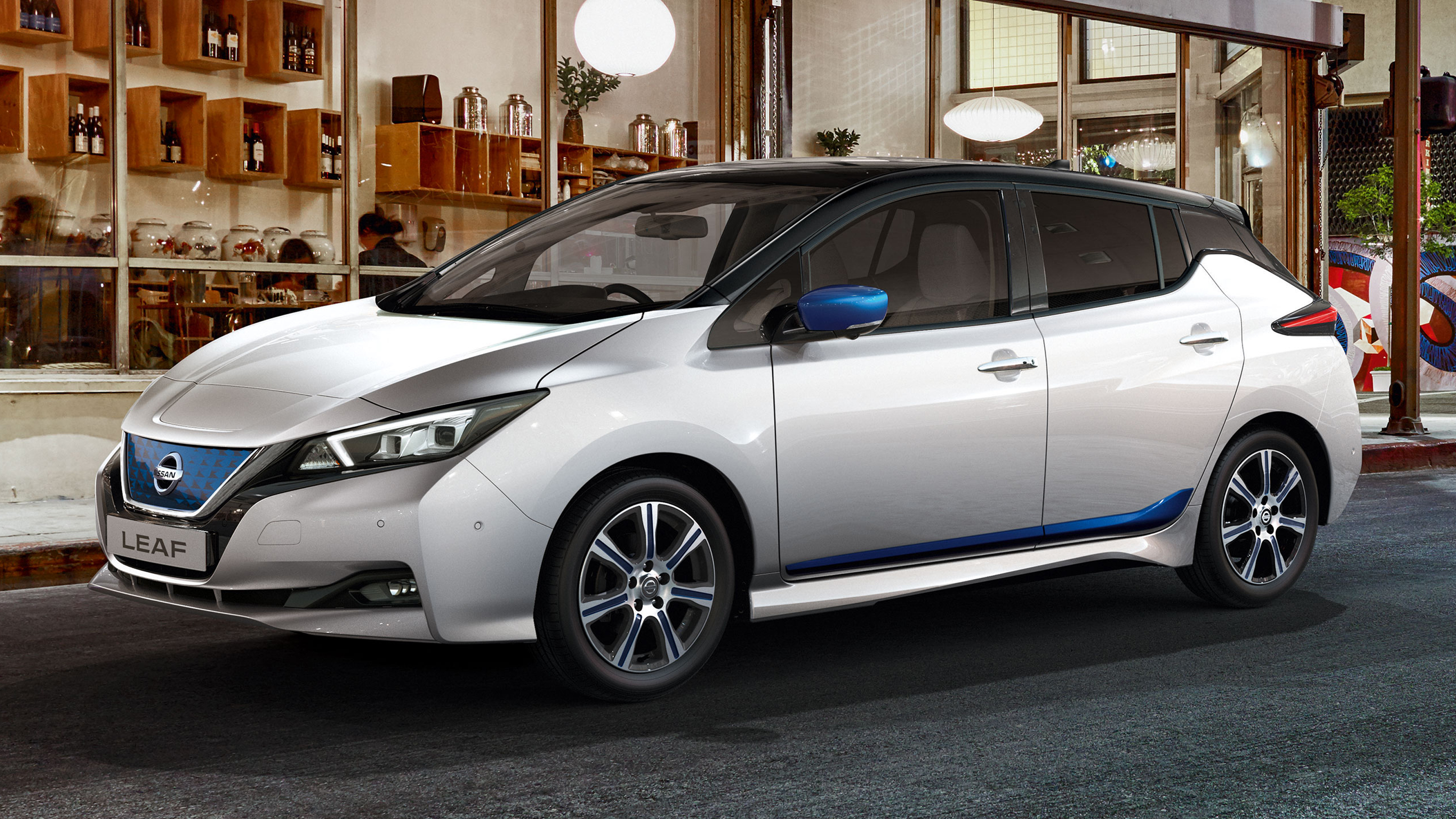 White Nissan Leaf parked outside a restaurant
