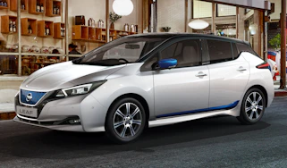 White Nissan Leaf parked outside a restaurant
